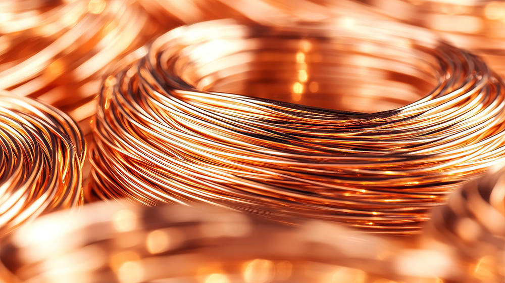 Coiled copper wires stacked together, close-up view, with intricate patterns.