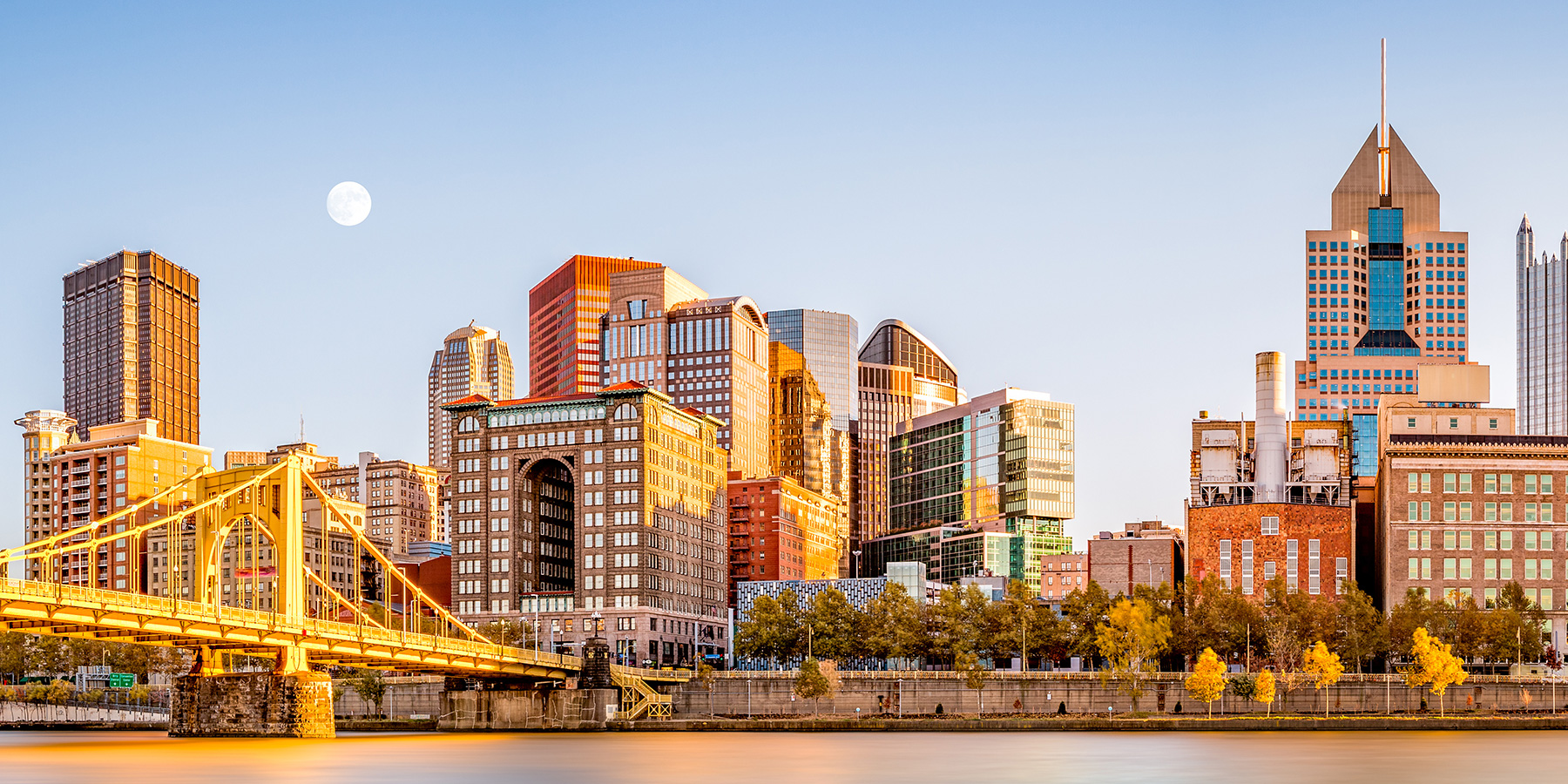 Long exposure of Pittsburgh downtown skyline and Roberto Clemente bridge, on a sunny afternoon, as viewed from North Shore Riverfront Park, across Allegheny River.